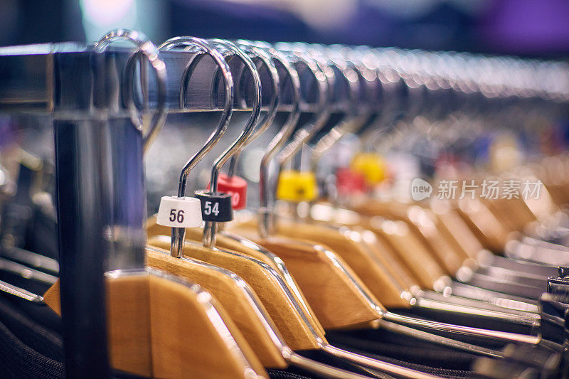 Showcase with men's trousers on hangers in a men's store.